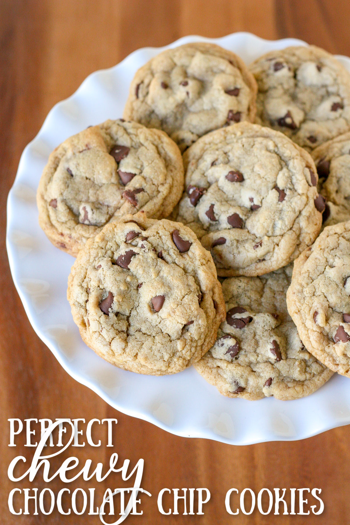 https://www.glorioustreats.com/wp-content/uploads/2013/09/chocolate-chip-cookies-piled-on-white-cake-stand-with-wood-surface-underneath-and-text-overlay-at-the-bottom.jpg