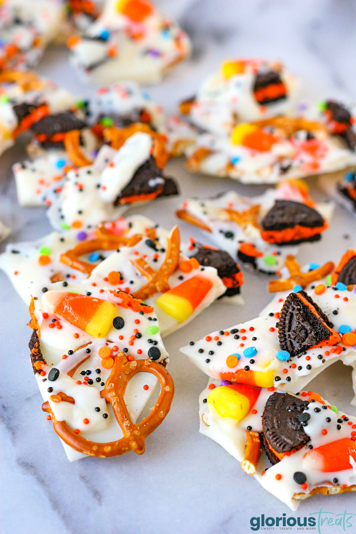 Halloween candy bark broken into pieces and sitting on marble surface.