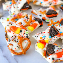 Halloween candy bark broken into pieces and sitting on marble surface.