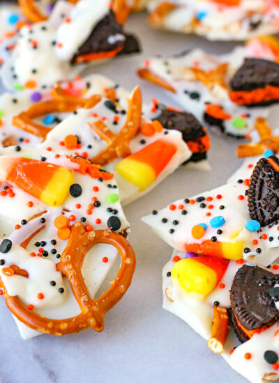 Halloween candy bark broken into pieces and sitting on marble surface.