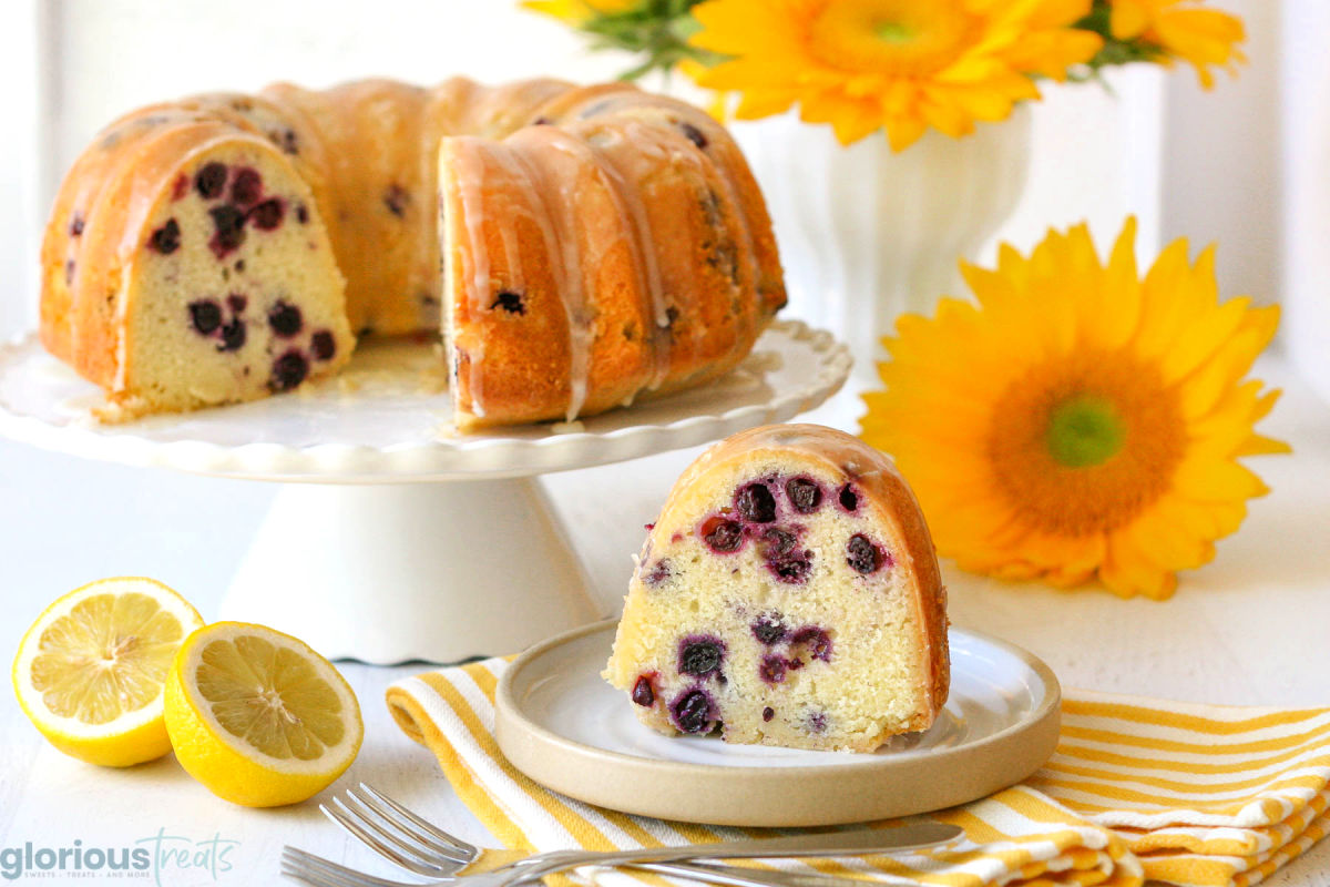 a bundt cake on a white cake plate with a slice cut out of it and that slice is sitting in front of it on a white plate