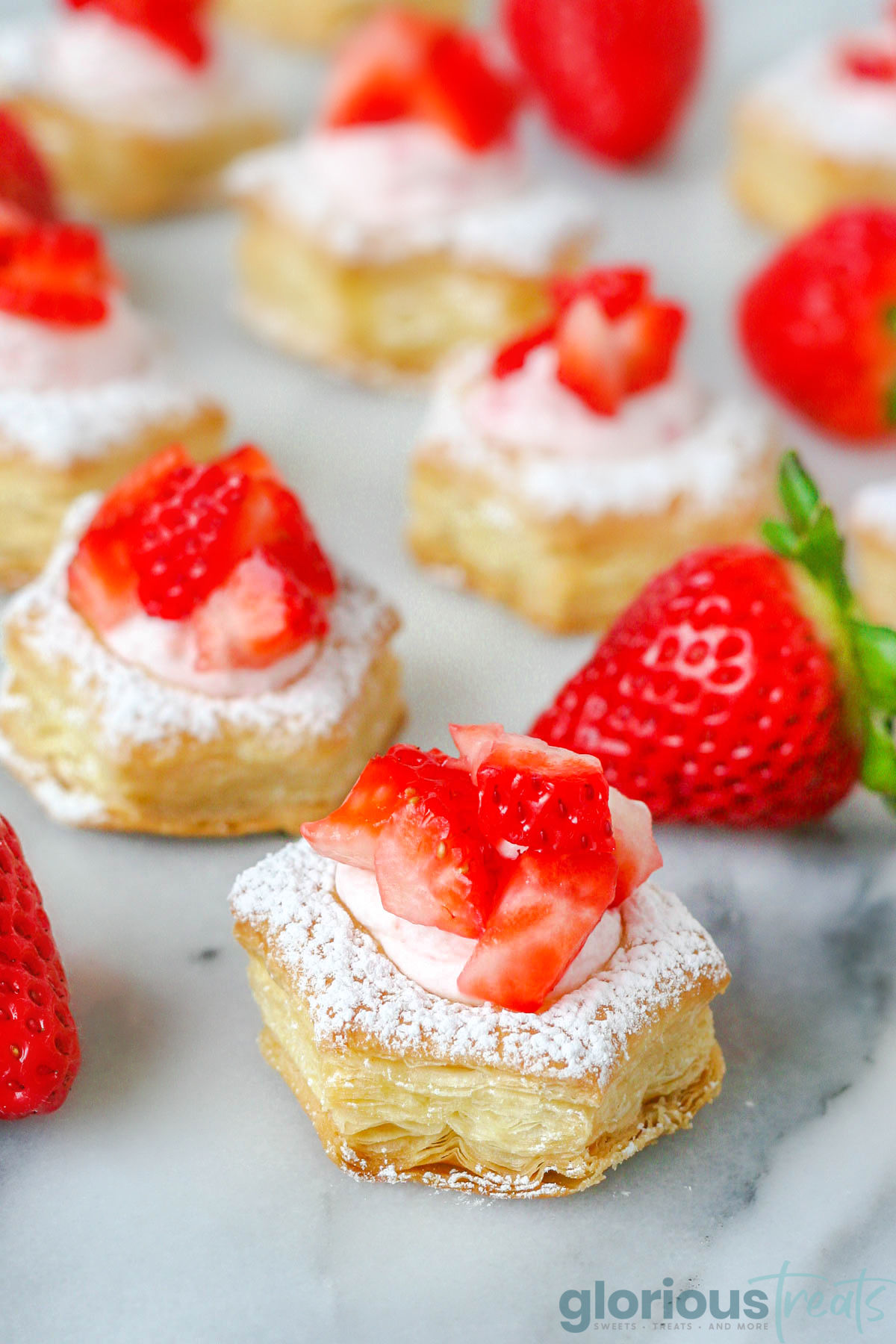 an assortment of cream puffs filled with strawberry filling and topped with chopped strawberries