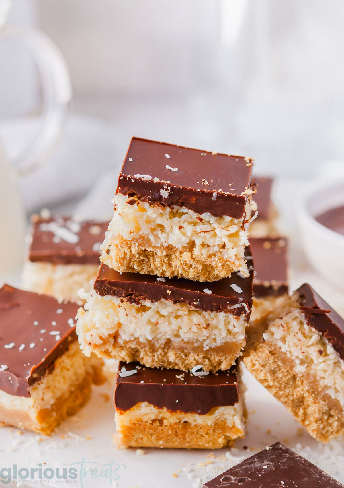 Chocolate coconut bars stacked on top of each other.