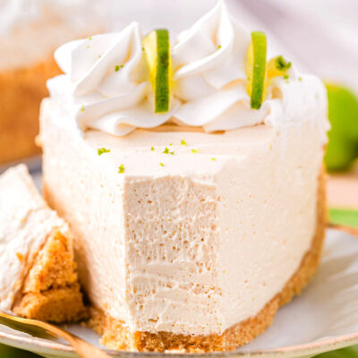 A slice of key lime cheesecake with a bite taken out of it.