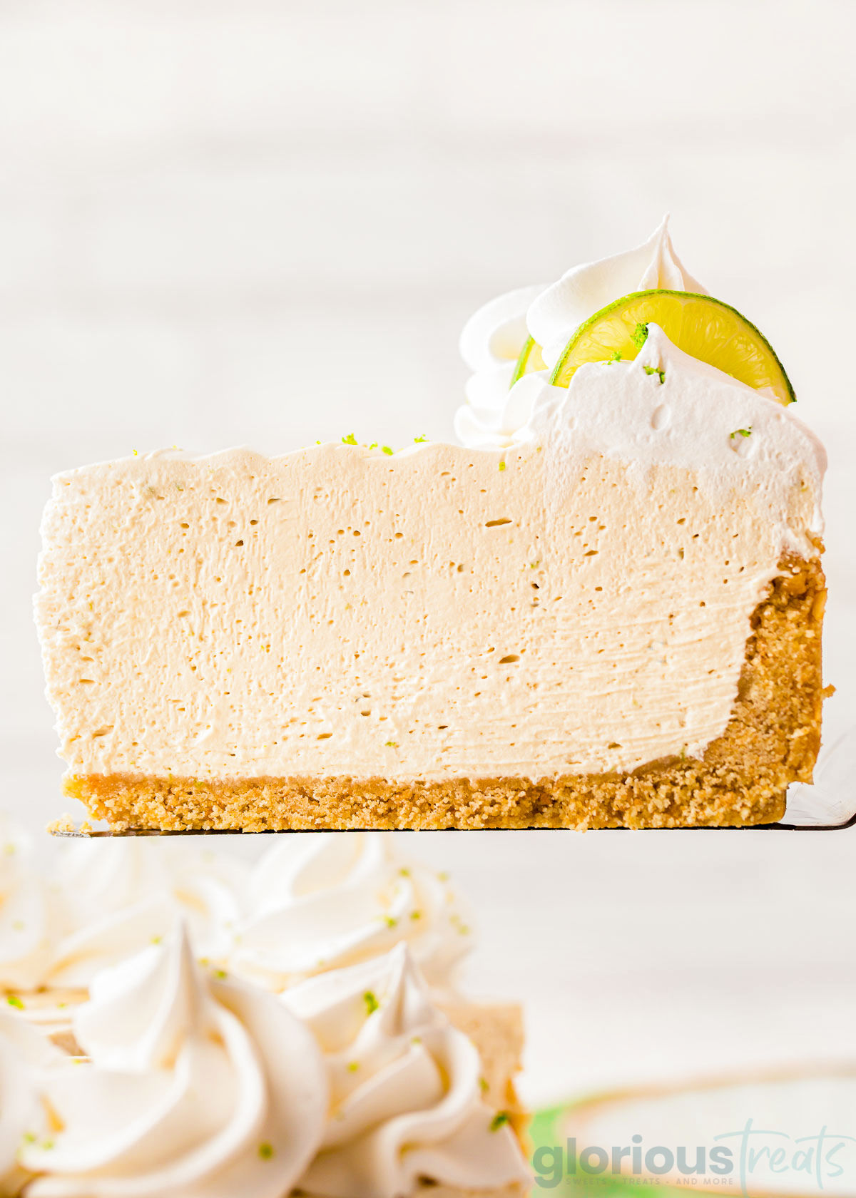 A slice of key lime cheesecake on a spatula.