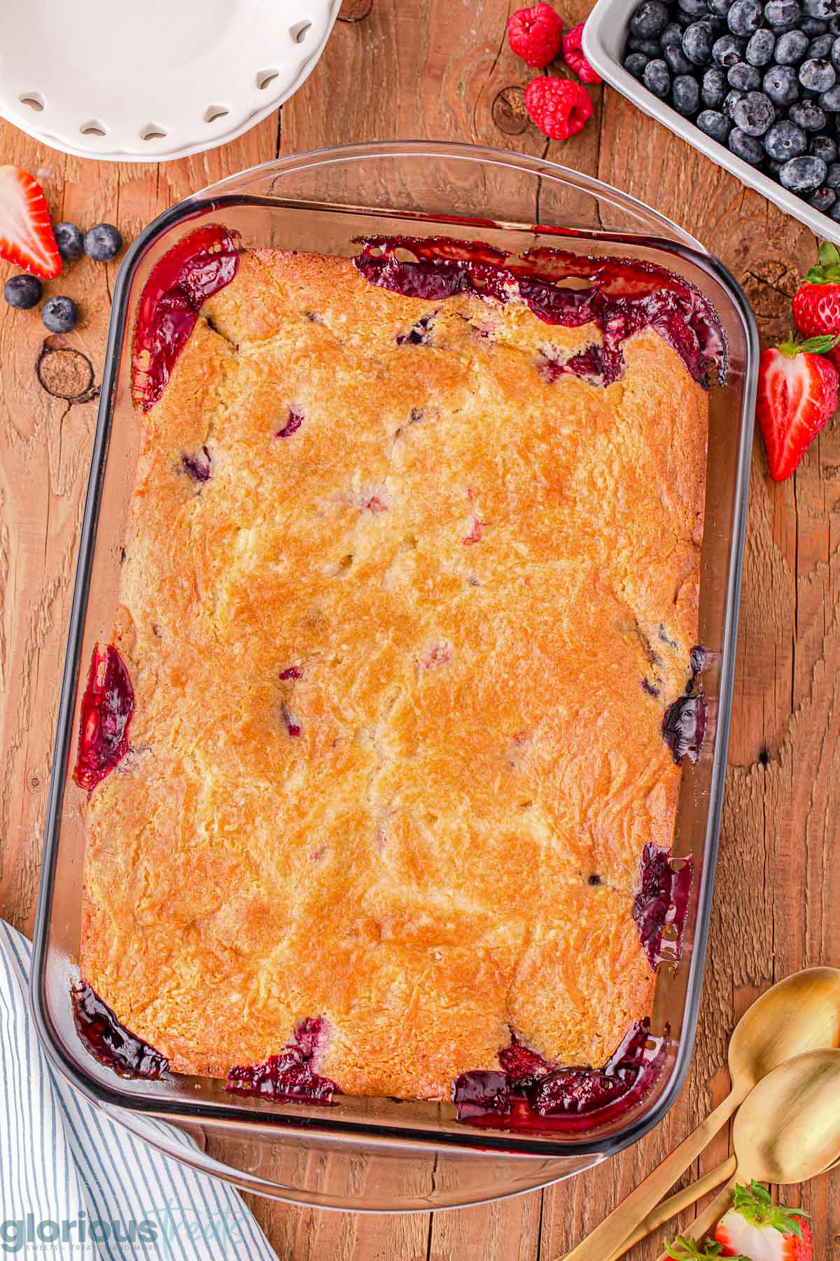 A top down shot of berry cobbler in a glass pan.