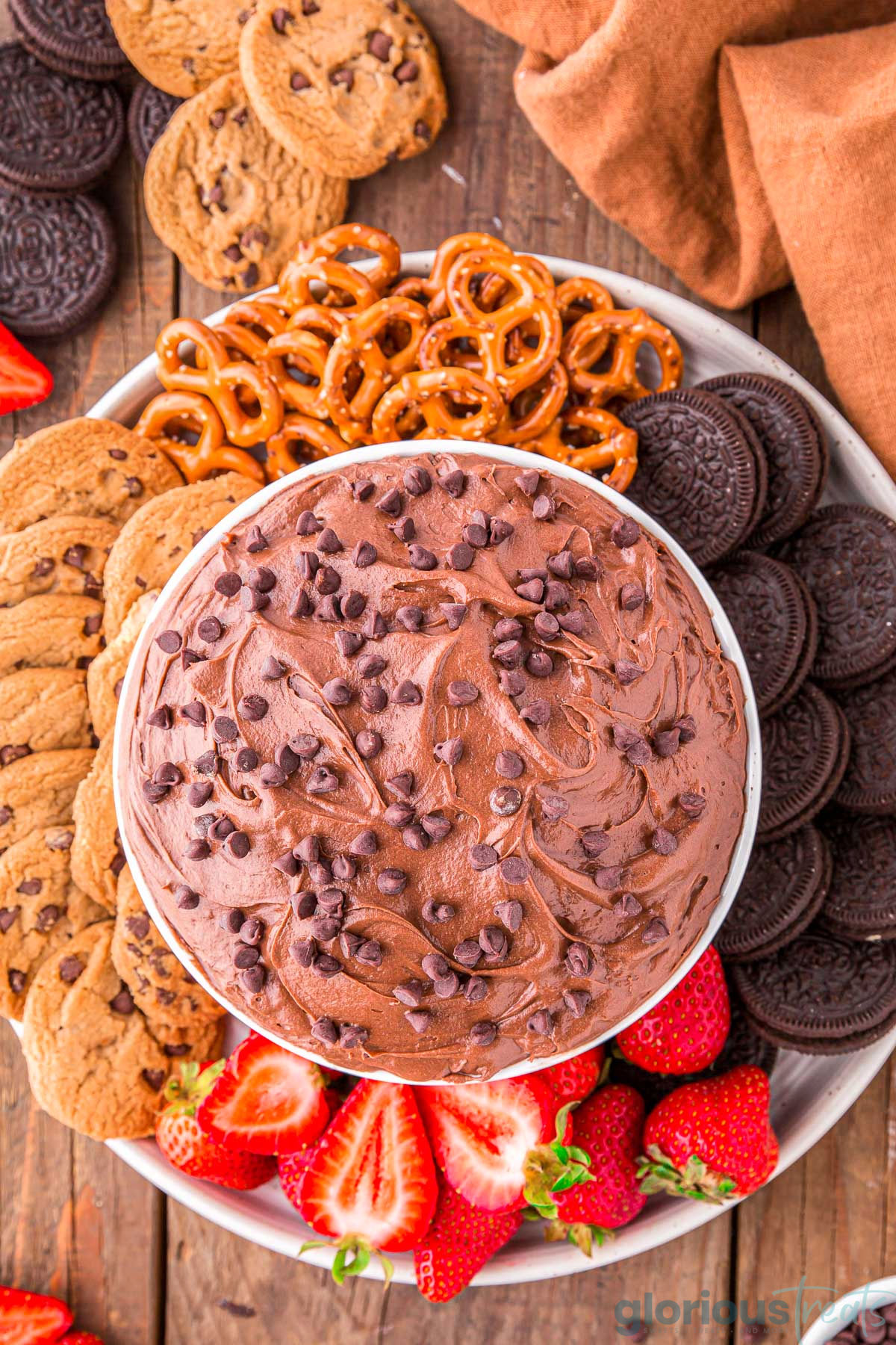 A top down view of brownie batter dip in a white bowl surrounded by dippers.