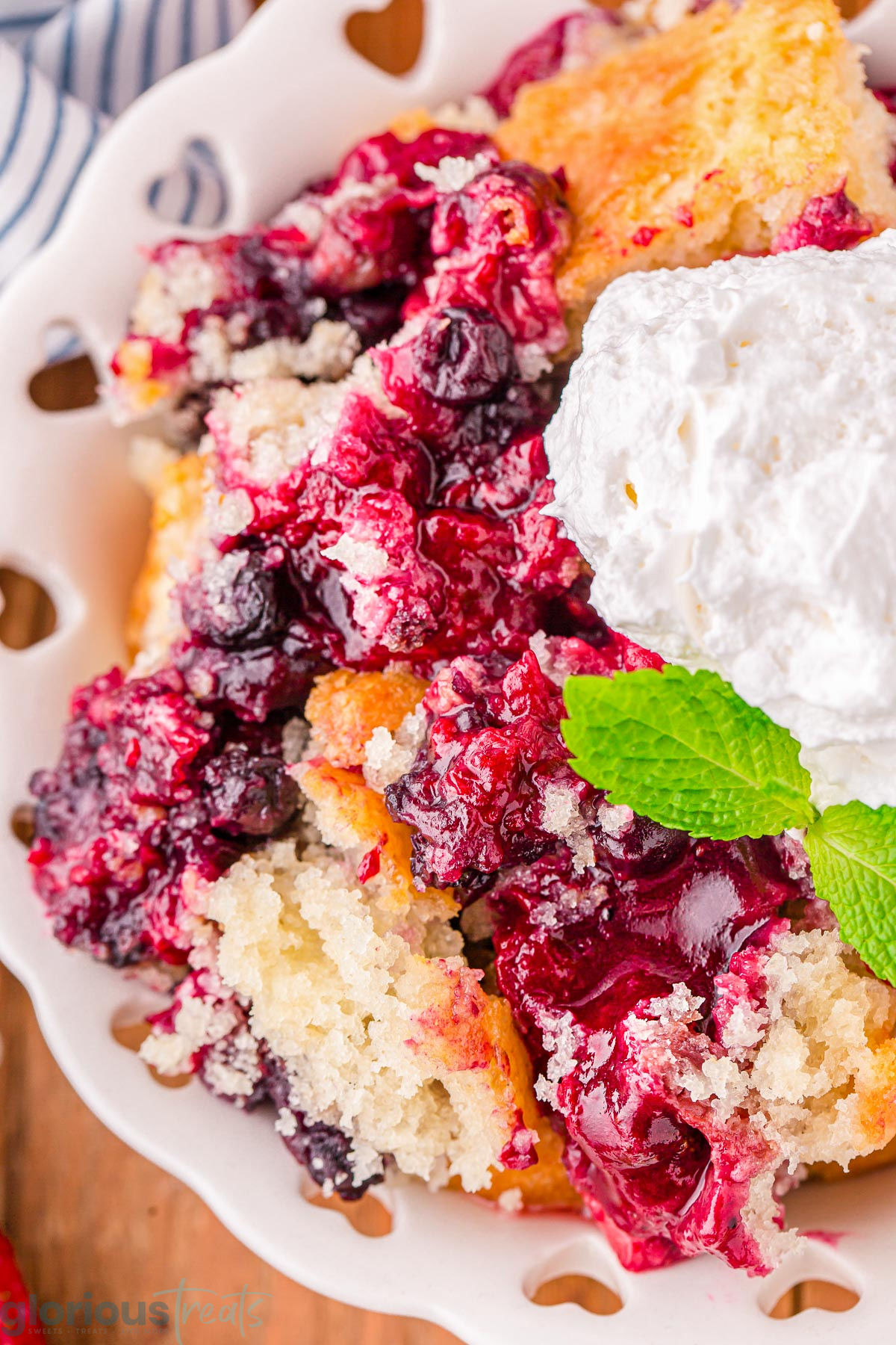 A close up photo of berry cobbler on a white plate.