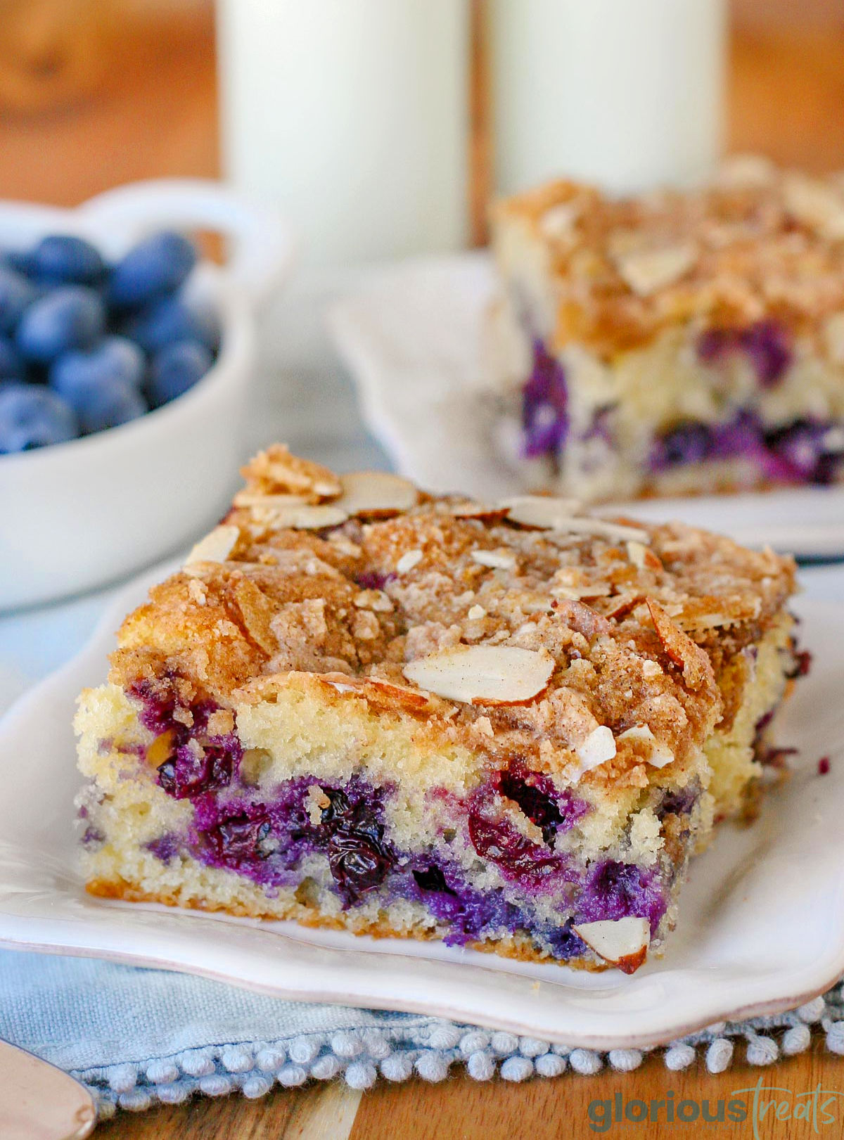 A slice of blueberry coffee cake on a white plate.