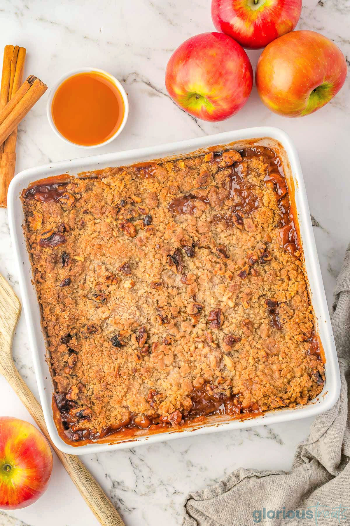 A top down shot of apple crumble in a white pan.