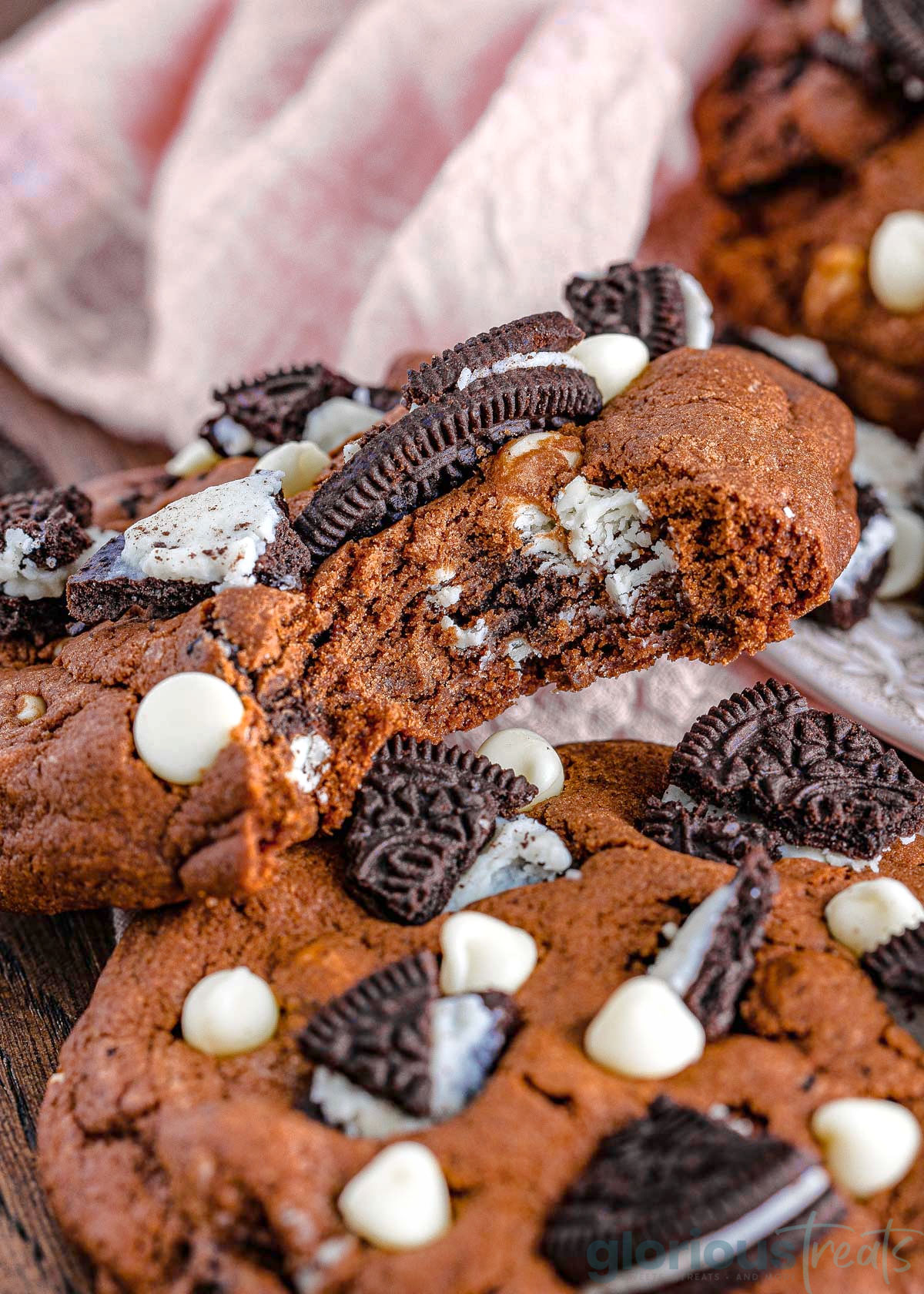 A close up of a cookies and cream cookie with a bite taken out of it.