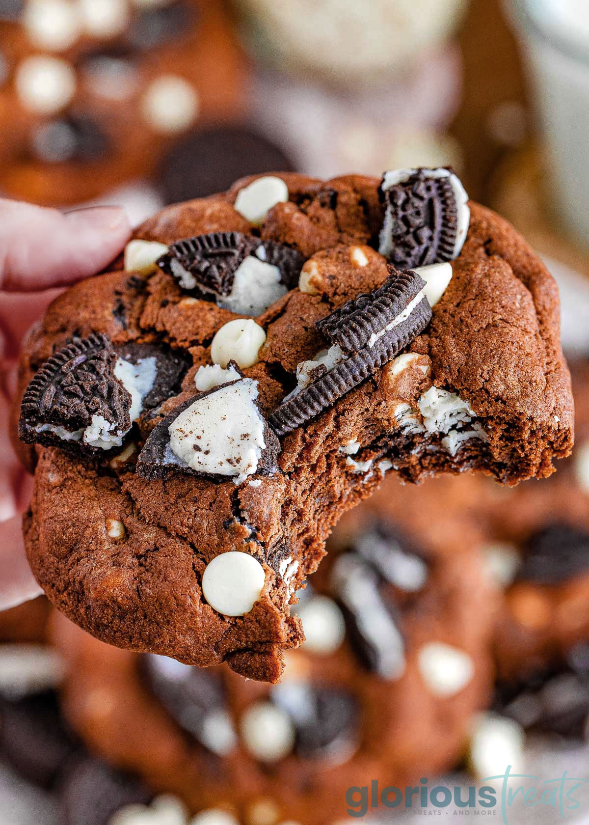 A close up of a cookies and cream cookie with a bite taken out of it.