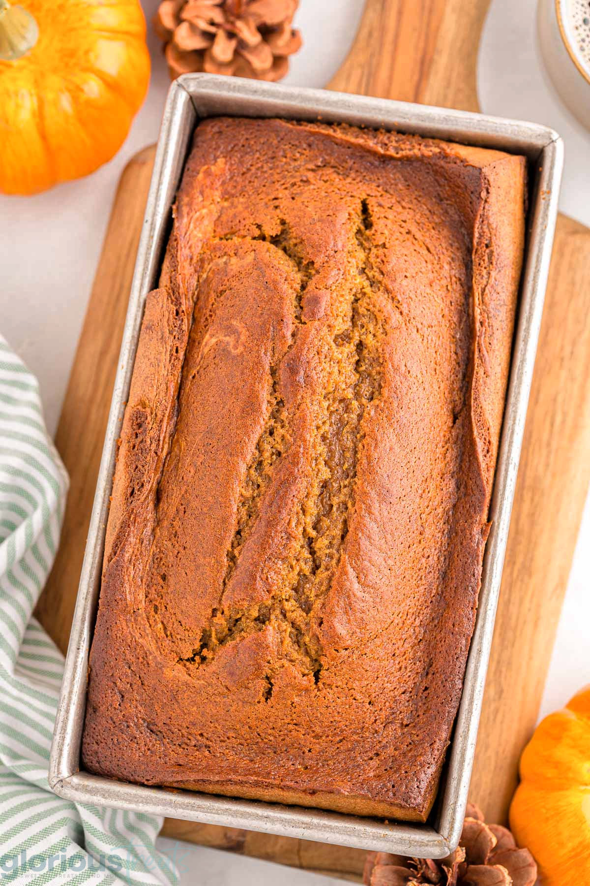 A top down view of pumpkin cream cheese bread in a bread pan.