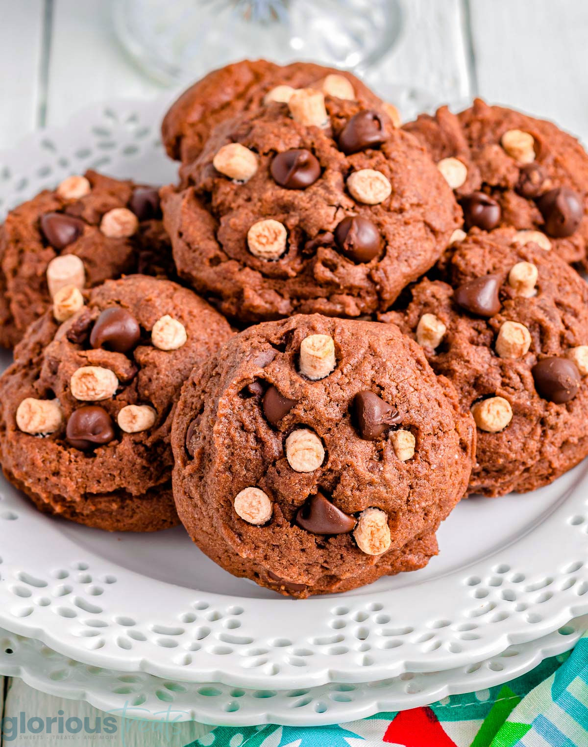 A pile of hot chocolate cookies on a decorative white plate.