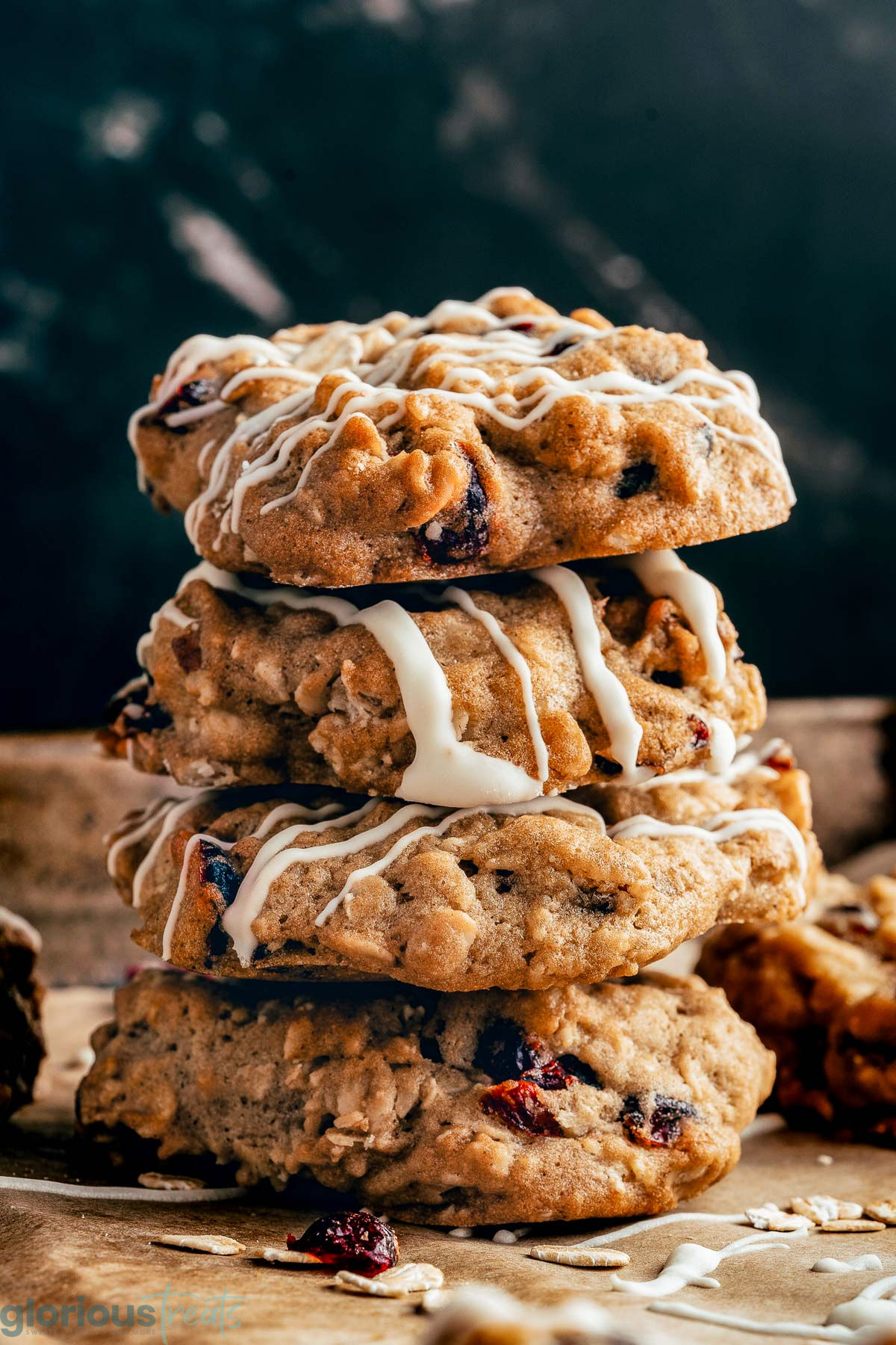 A stack of oatmeal cranberry cookies on a piece of brown parchment paper.