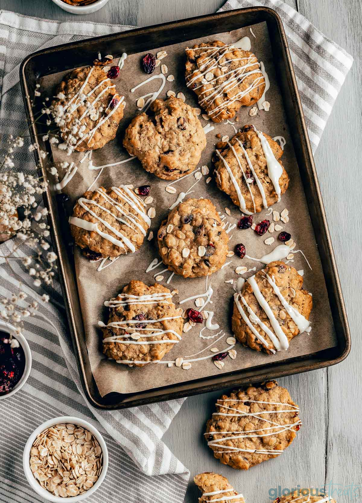 A top down view of cranberry oatmeal cookies on a baking sheet.