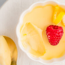 Lemon Posset in a decorative white bowl with a scoop taken out of it.