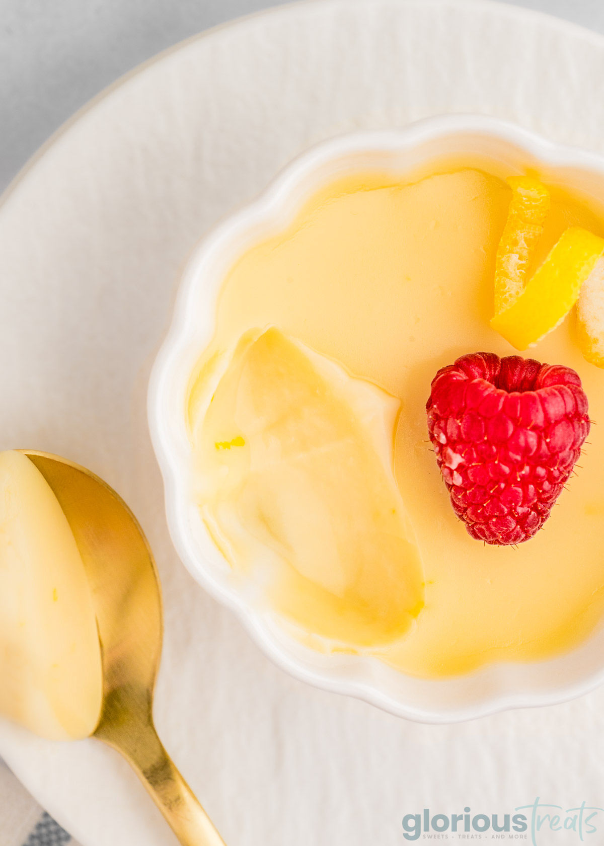 Lemon Posset in a decorative white bowl with a scoop taken out of it.