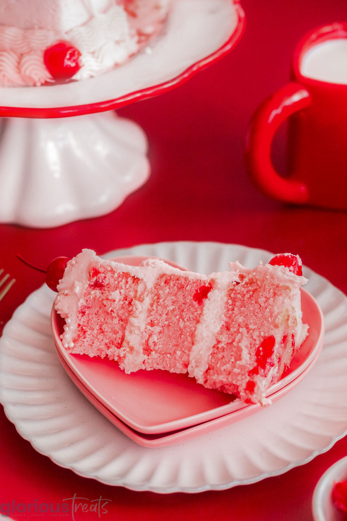 Slice of cherry cake on a heart shaped plate.